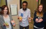 three students holding painted kindness rocks