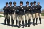 8 people wearing black riding helmets, black jackets, tan pants & 黑色的靴子