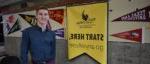 student standing next to a Black Hawk College banner that reads 