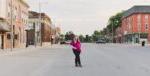 woman stands in the street in downtown Aledo