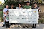 6 people standing outdoors with oversized check